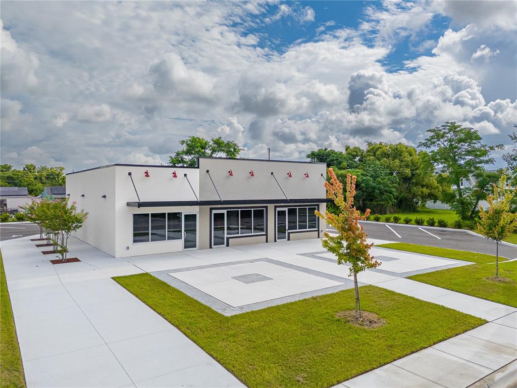 An exterior view of a modern, single-story commercial building with a concrete parking lot — 215 CENTER STREET UNIT 227, WINTER GARDEN, FL