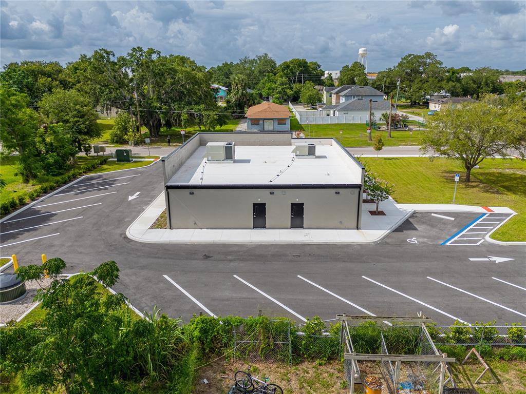 An aerial view shows a modern commercial building with a flat roof and parking lot — 215 CENTER STREET UNIT 227, WINTER GARDEN, FL