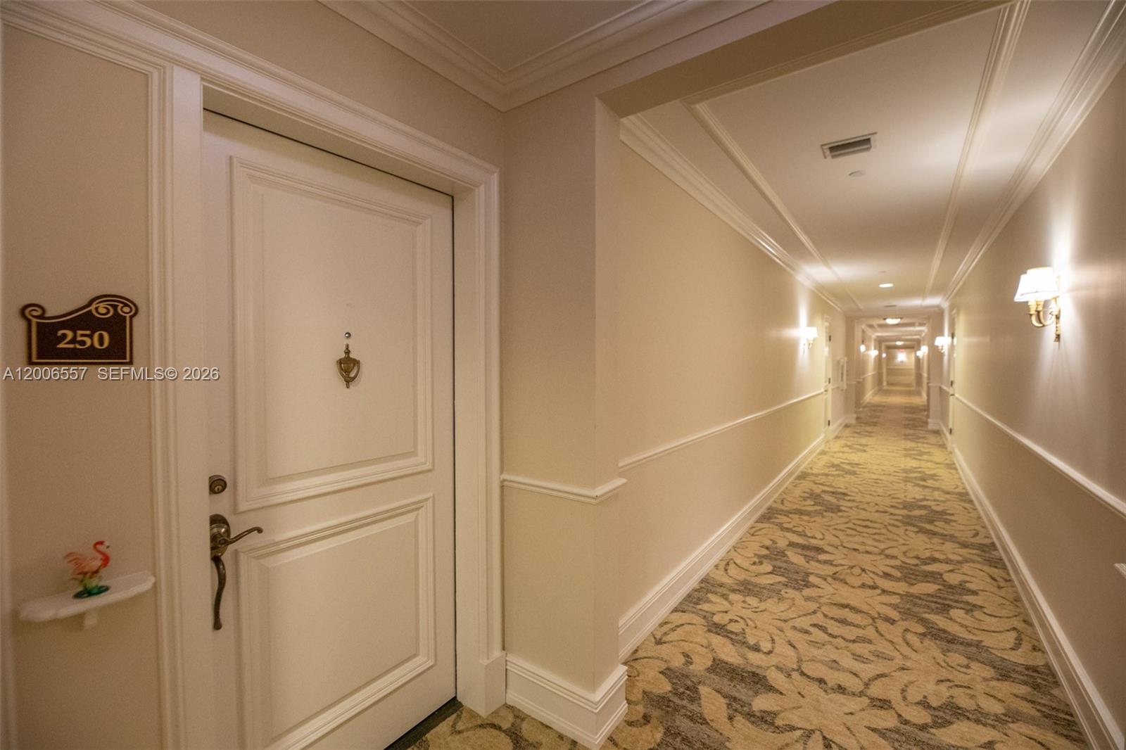 A long hotel hallway features beige walls, patterned carpeting, and a door labeled 250 — 16101 Emerald Estates Dr # 250, Weston FL 33331, WESTON, FL