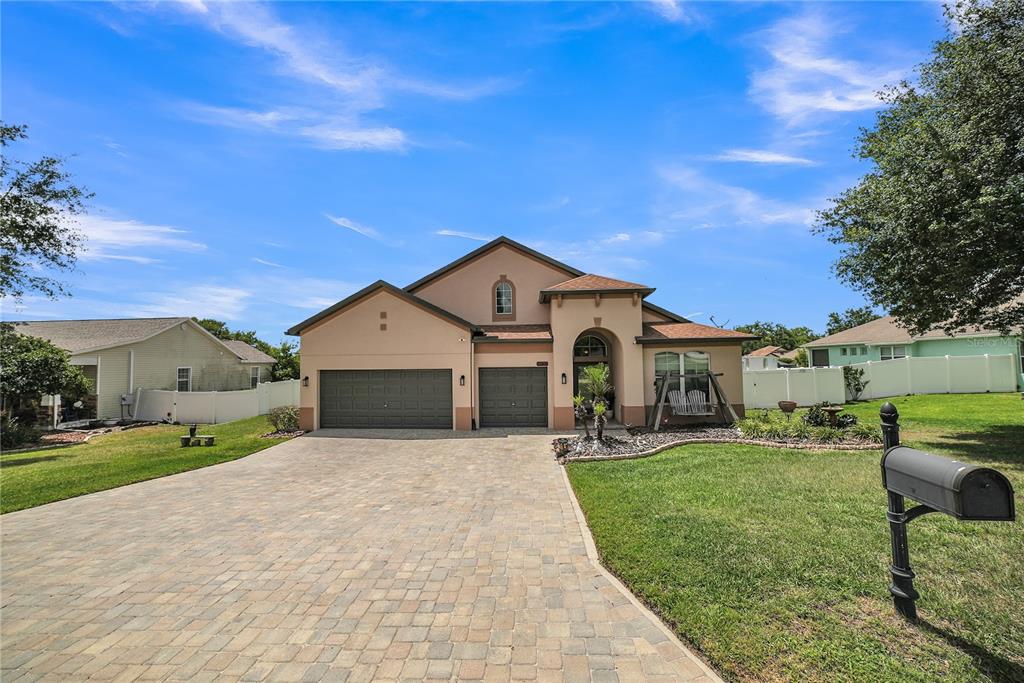 A single-story house with a paved driveway, two garage doors, and a front porch — 12309 LOOPBACK DRIVE, SAN ANTONIO, FL