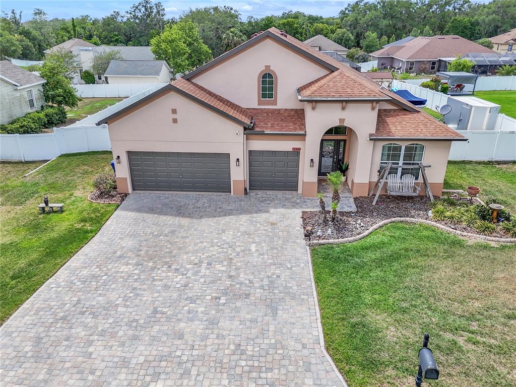 An aerial view of a single-story house with a paved driveway and a two-car garage — 12309 LOOPBACK DRIVE, SAN ANTONIO, FL