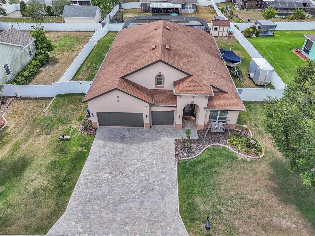 An aerial view of a single-story house with a paver driveway and a brown roof — 12309 LOOPBACK DRIVE, SAN ANTONIO, FL