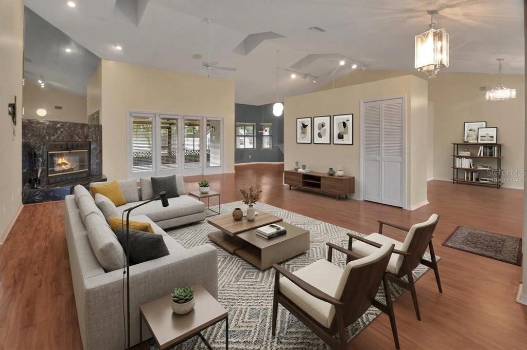 A living room with a fireplace, hardwood floors, and a sectional sofa on a rug — 2465 ROYAL ROAD, DELAND, FL