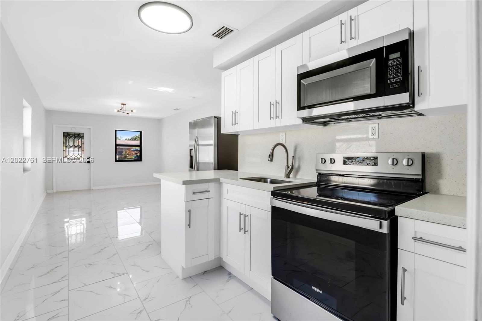 A kitchen with white cabinets, stainless steel appliances, and light-colored tile flooring — 6312 SW 19th St # 1, Miramar FL 33023, MIRAMAR, FL
