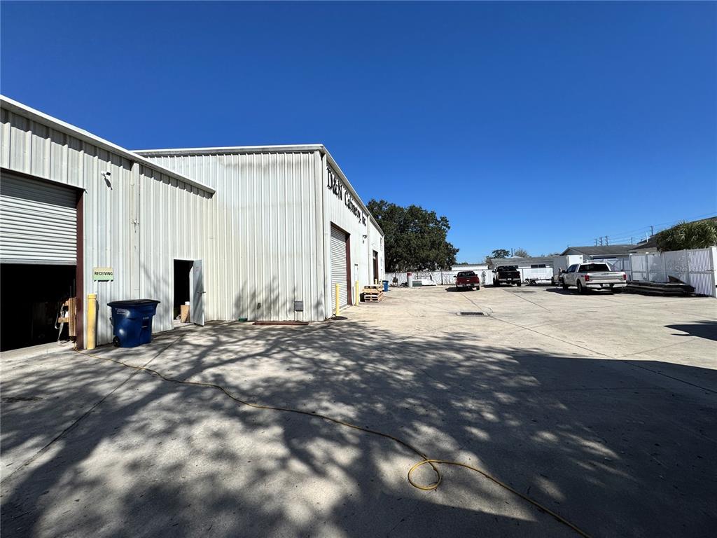 The exterior of a metal industrial building features a receiving bay and a concrete parking lot — 2914 KENILWORTH BOULEVARD, SEBRING, FL