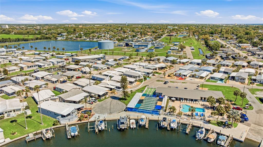 An aerial view shows a mobile home community with a marina, pool, and circled residence — 2810 14TH STREET W, PALMETTO, FL