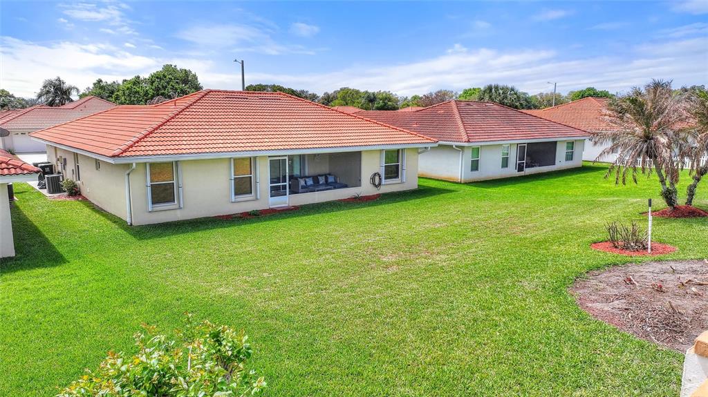 The exterior view shows the back of a house with a screened-in patio and lawn — 144 MORNING GLORY CIRCLE, WINTER HAVEN, FL