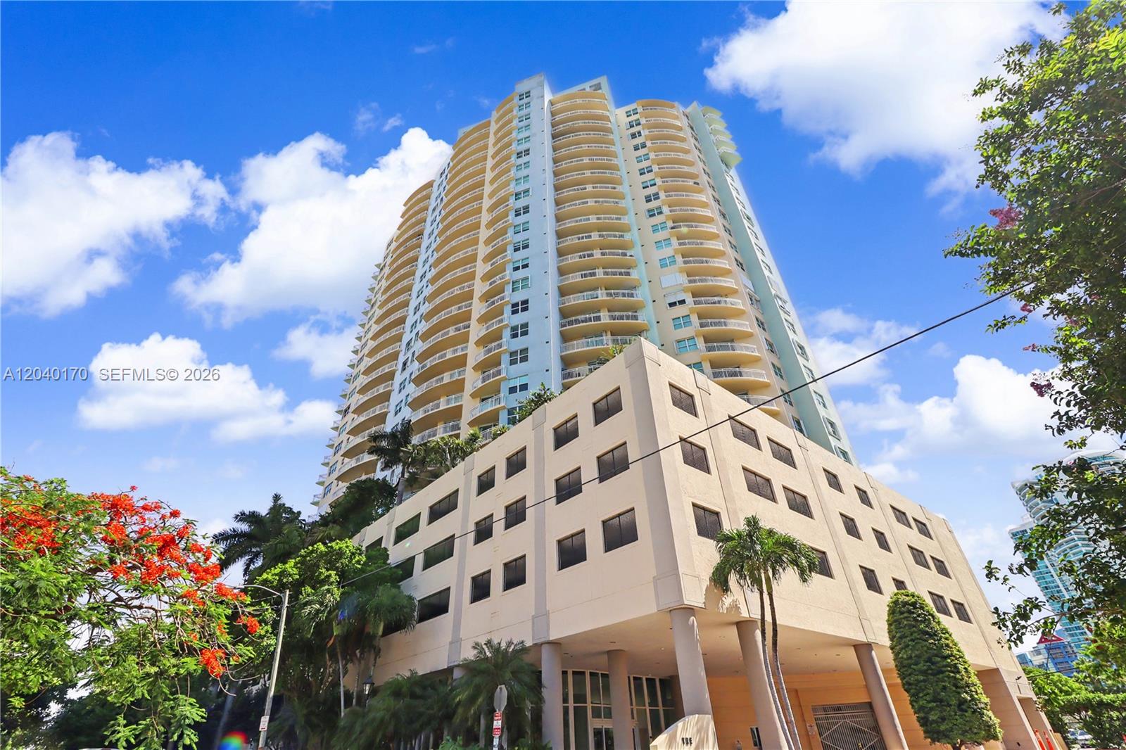 A tall residential high-rise building features a multi-story parking garage base and curved balconies — 2475 Brickell Ave # 704, Miami FL 33129, MIAMI, FL