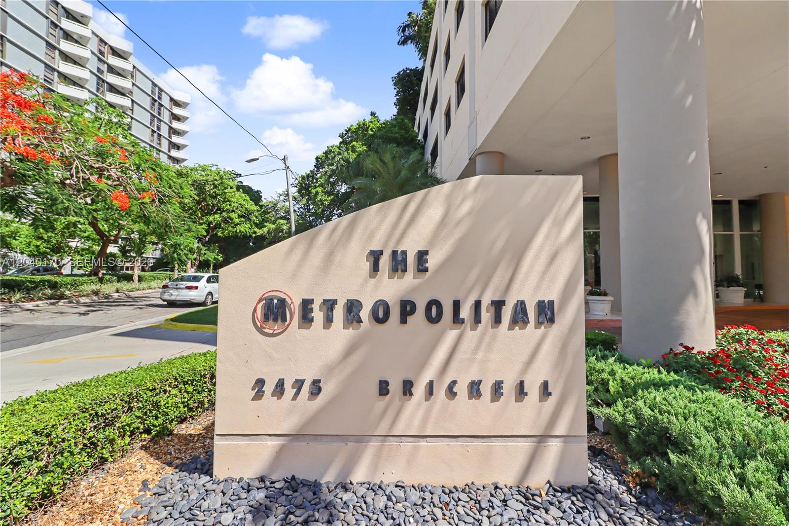 A beige monument sign for The Metropolitan stands in front of a multi-story building — 2475 Brickell Ave # 704, Miami FL 33129, MIAMI, FL