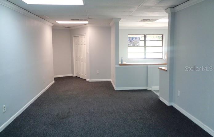 An empty office space with gray walls, dark carpeting, a drop ceiling, and a window — 7444 S FEDERAL HWY HIGHWAY, PORT ST LUCIE, FL