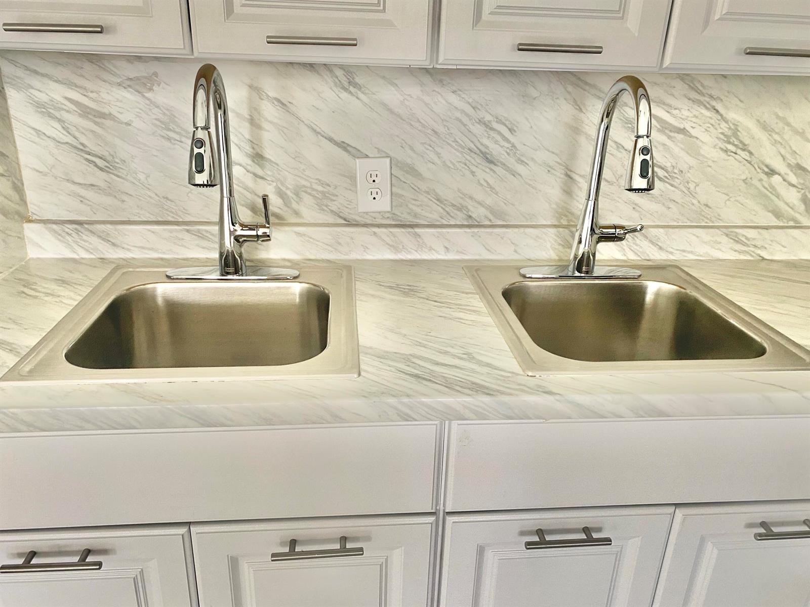 A kitchen counter features two stainless steel sinks with chrome faucets and marble-patterned surfaces — 341 Windsor O, West Palm Beach FL 33417, WEST PALM BEACH, FL