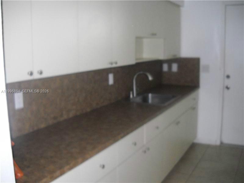 A kitchen features white cabinets, a dark countertop, and a stainless steel sink — 1040 92 ST # 3, Bay Harbor Islands FL 33154, BAY HARBOR ISLANDS, FL