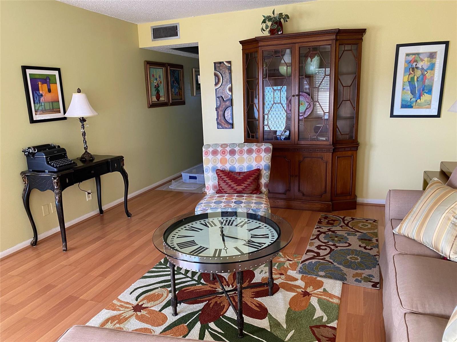 A living room features a clock coffee table, patterned accent chair, and a wooden hutch — 19 Ashby A # 19, Deerfield Beach FL 33442, DEERFIELD BEACH, FL