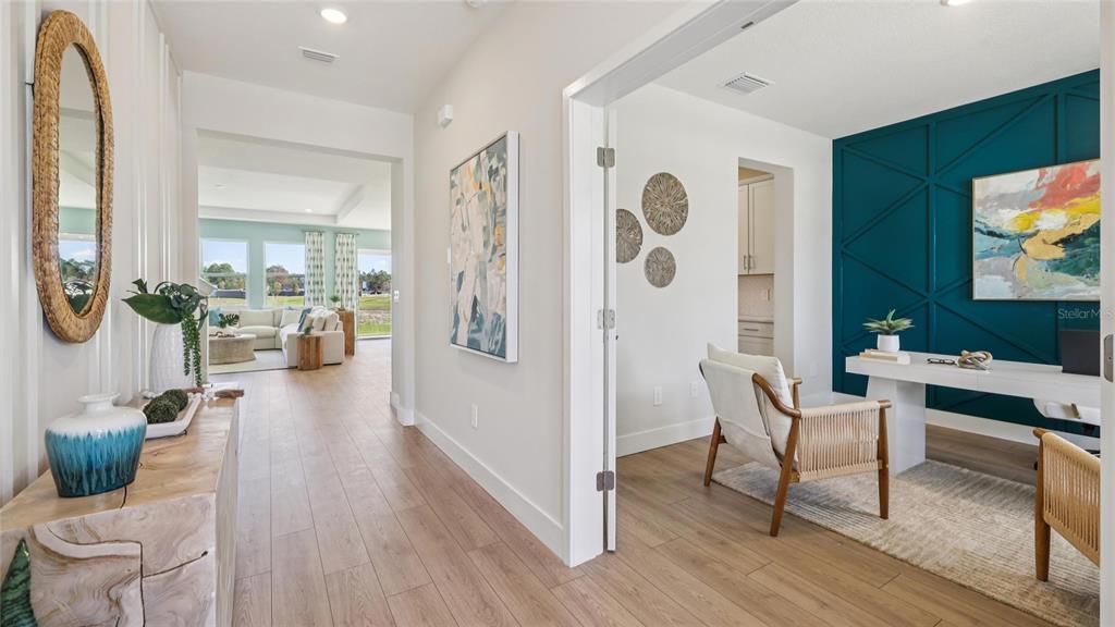 A hallway leads to a living area, with a home office featuring a teal wall — 17061 NW 180TH TERRACE, ALACHUA, FL