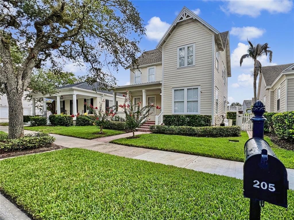 A two-story light-colored house with a front porch and a mailbox in the foreground — 205 N VILLAGE STREET, CELEBRATION, FL