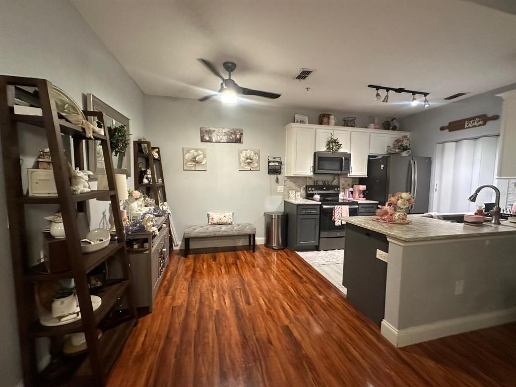 A kitchen with dark cabinets, stainless steel appliances, and a central island with a sink — 875 GRAND REGENCY POINT UNIT 203, ALTAMONTE SPRINGS, FL