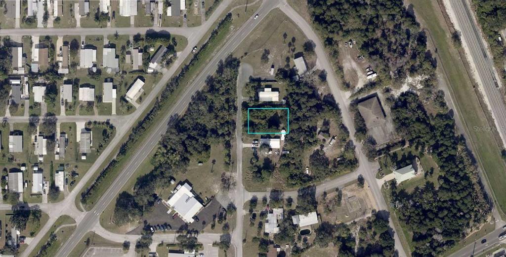 This is an aerial view of a wooded residential lot outlined in blue — 828 LOUISIANA AVENUE, SEBASTIAN, FL