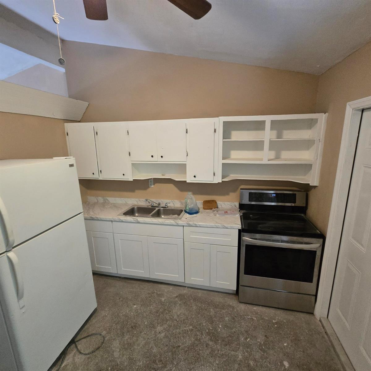 A kitchen features white cabinets, a stainless steel stove, a white refrigerator, and concrete floors — 830 SW 14th Street # 2, Pompano Beach FL 33060, POMPANO BEACH, FL