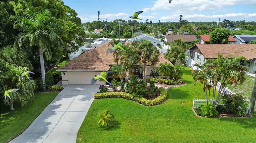An aerial view of a single-story house with a brown roof, driveway, and green lawn — 230 E GREEN STREET, ENGLEWOOD, FL