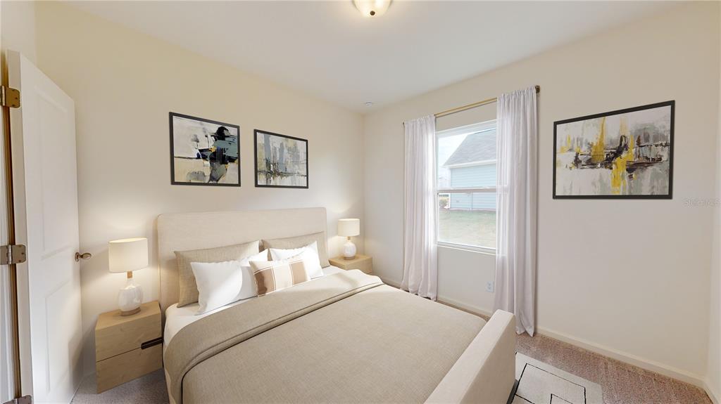 A bedroom features a bed with neutral bedding, two nightstands with lamps, and wall art — 14554 ITALY AVENUE, DADE CITY, FL