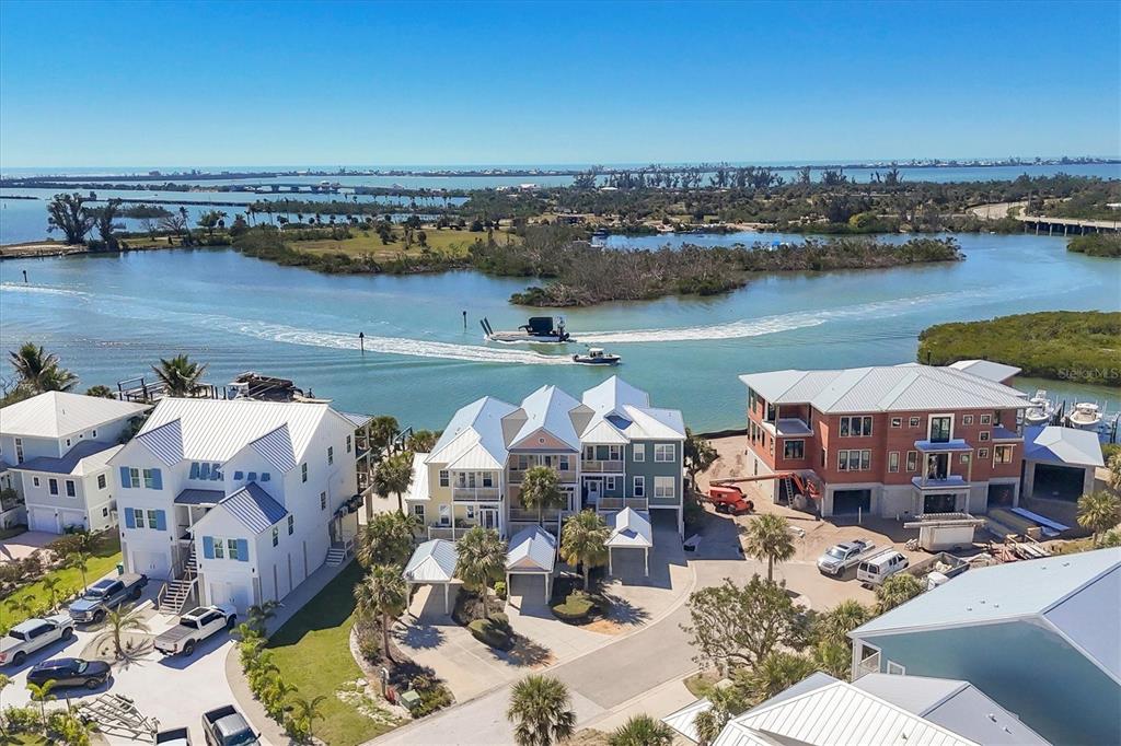 An aerial view of waterfront houses with a boat traveling through a canal nearby — 11727 ANGLERS CLUB DRIVE UNIT 132, PLACIDA, FL