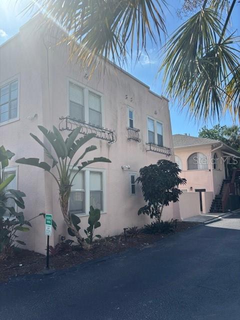A pale pink multi-story building features decorative window railings and a paved driveway — 1604 N OSCEOLA AVENUE, CLEARWATER, FL