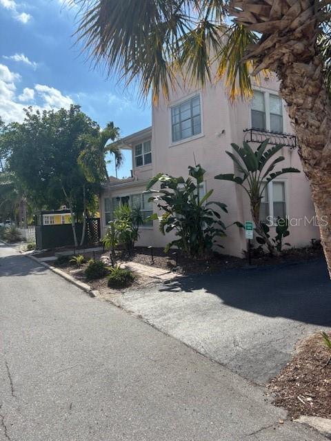 A light pink two-story building features a paved driveway, lush landscaping, and a palm tree — 1604 N OSCEOLA AVENUE, CLEARWATER, FL