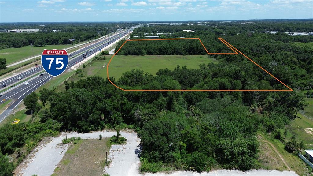 An aerial view shows a vacant, partially wooded lot adjacent to Interstate 75 — NW 37TH STREET, OCALA, FL