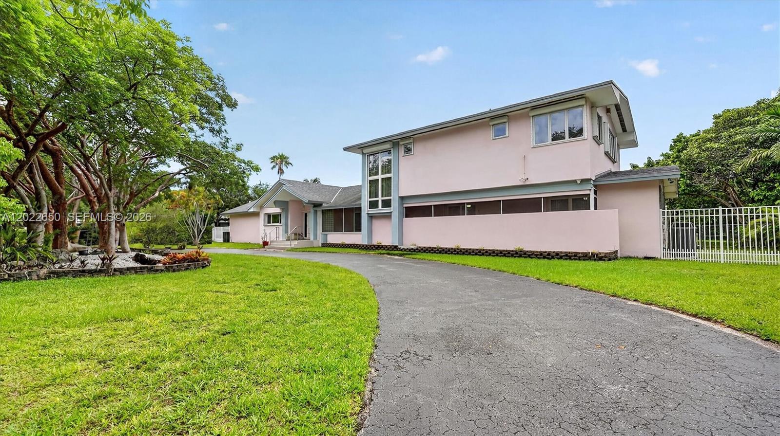 A two-story pink house with a curved driveway and a large tree in the yard — 11651 SW 64th Ave, Pinecrest FL 33156, PINECREST, FL