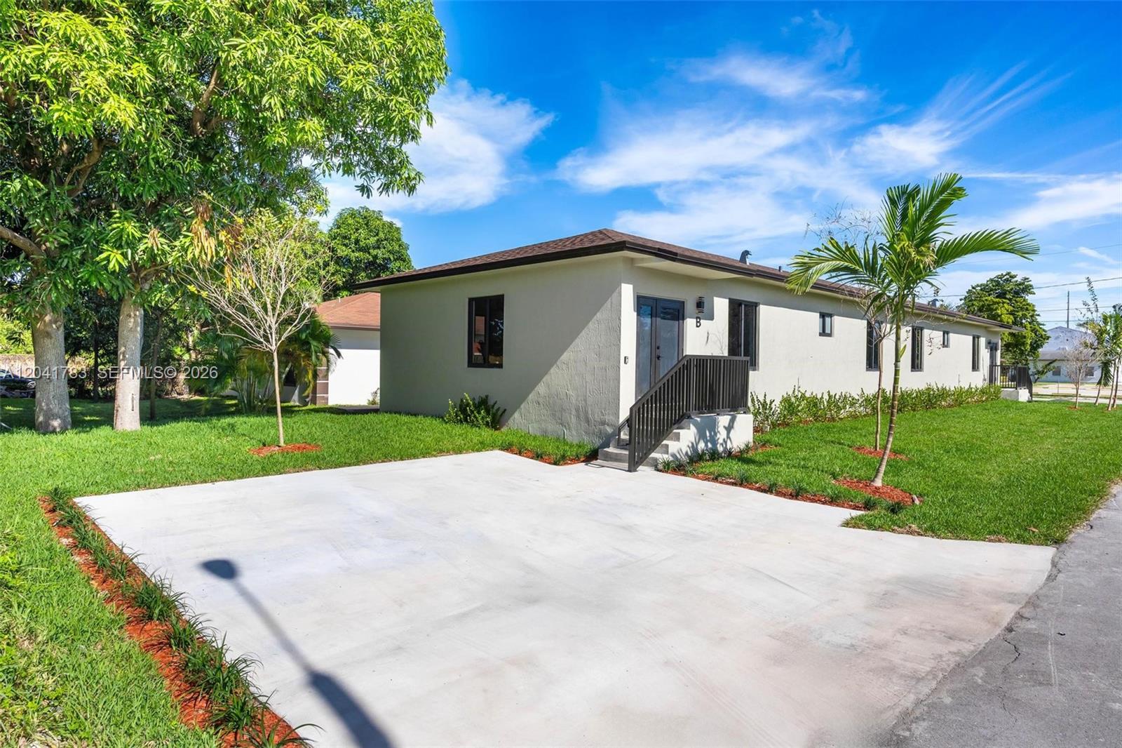 A single-story building with a concrete driveway, a small staircase, and a palm tree — 601 NW 3rd Ave, Hallandale Beach FL 33009, HALLANDALE BEACH, FL