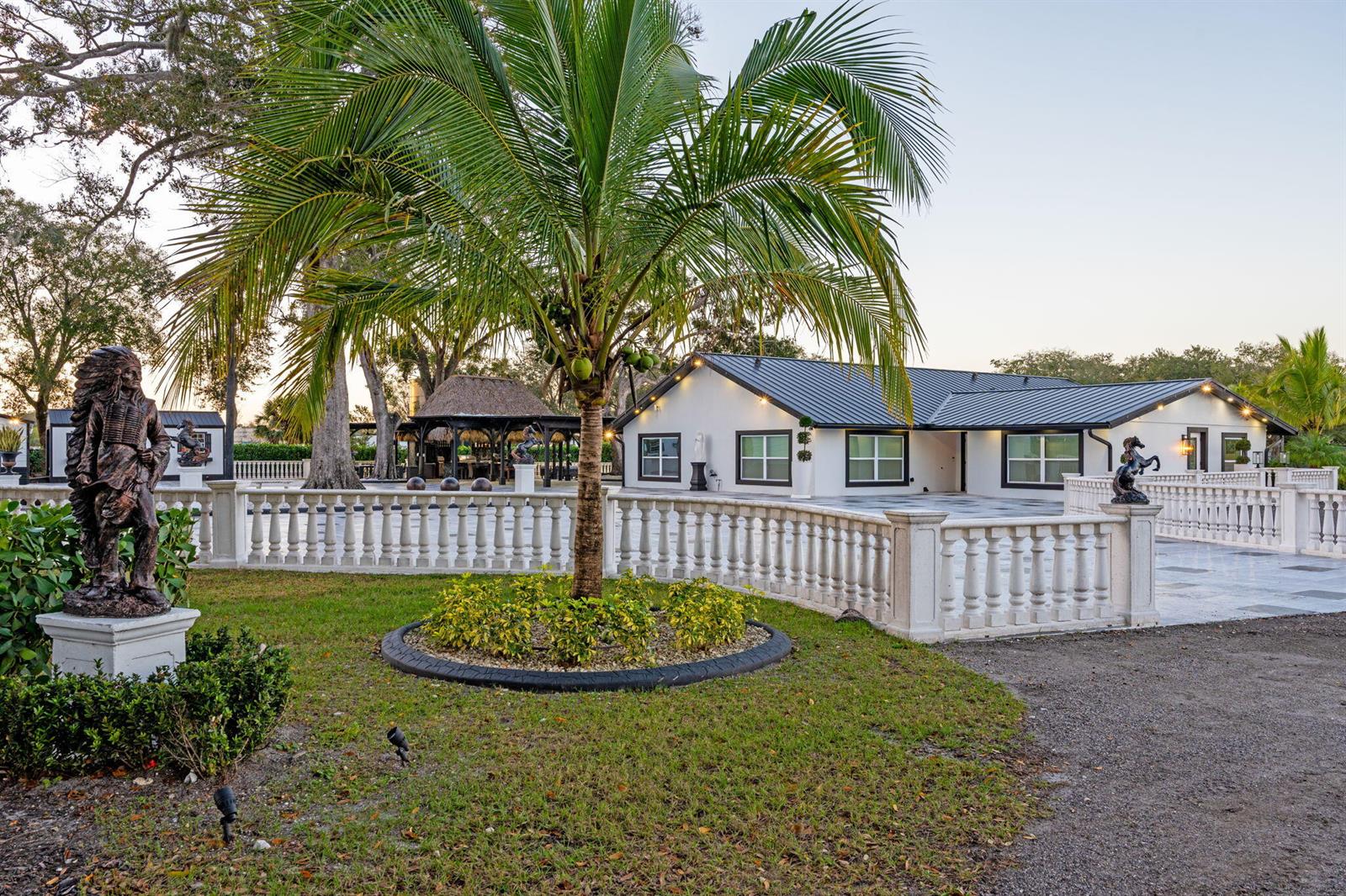 A white house with a metal roof sits behind a balustrade and a palm tree — 16200 Orange Avenue, Fort Pierce FL 34945, FORT PIERCE, FL