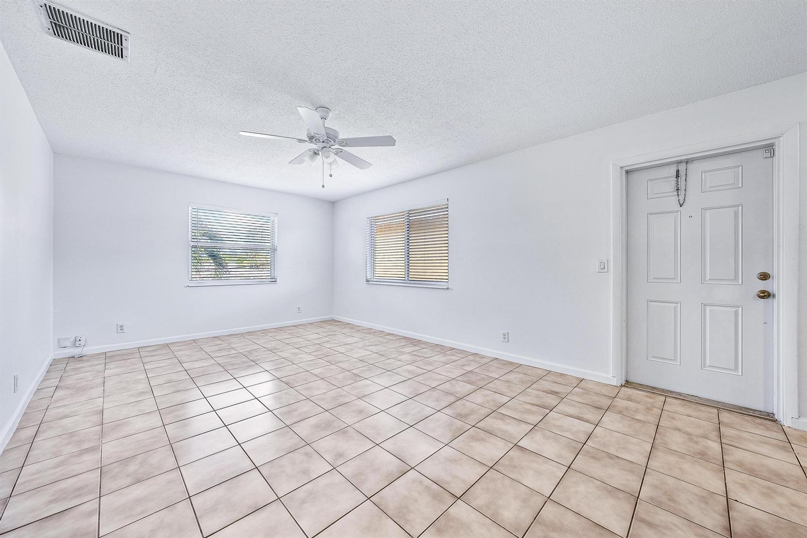An empty room with white walls, a ceiling fan, tiled floors, and two windows — 242 NE 12th Street # 2, Delray Beach FL 33444, DELRAY BEACH, FL