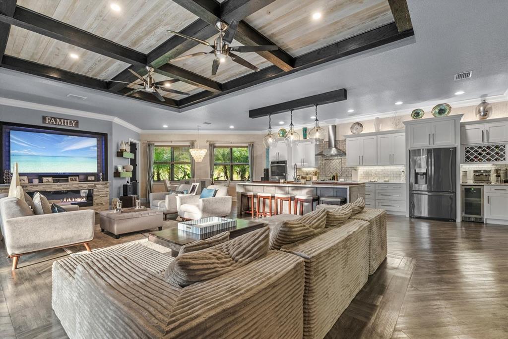 An open-concept living room and kitchen feature a coffered ceiling and wood-look flooring — 3604 TROPICAIRE BOULEVARD, NORTH PORT, FL
