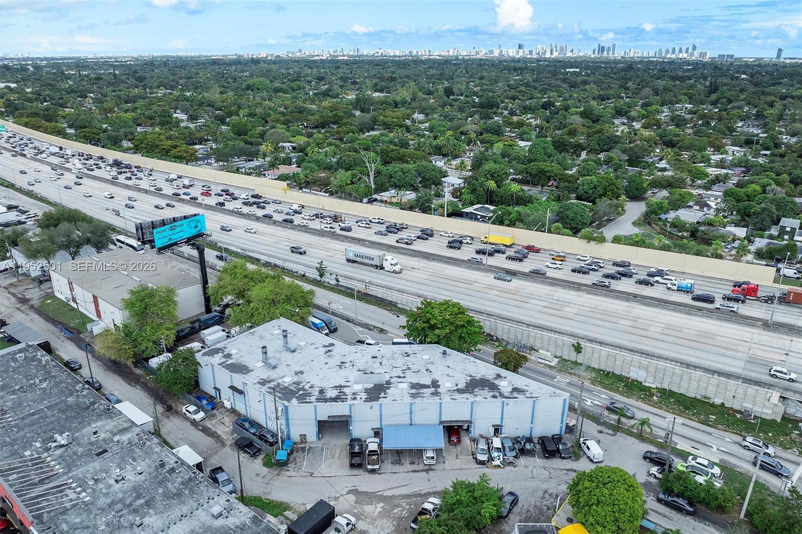An aerial view shows a commercial building with a parking lot adjacent to a highway — 660 NW 137th St, North Miami FL 33168, NORTH MIAMI, FL