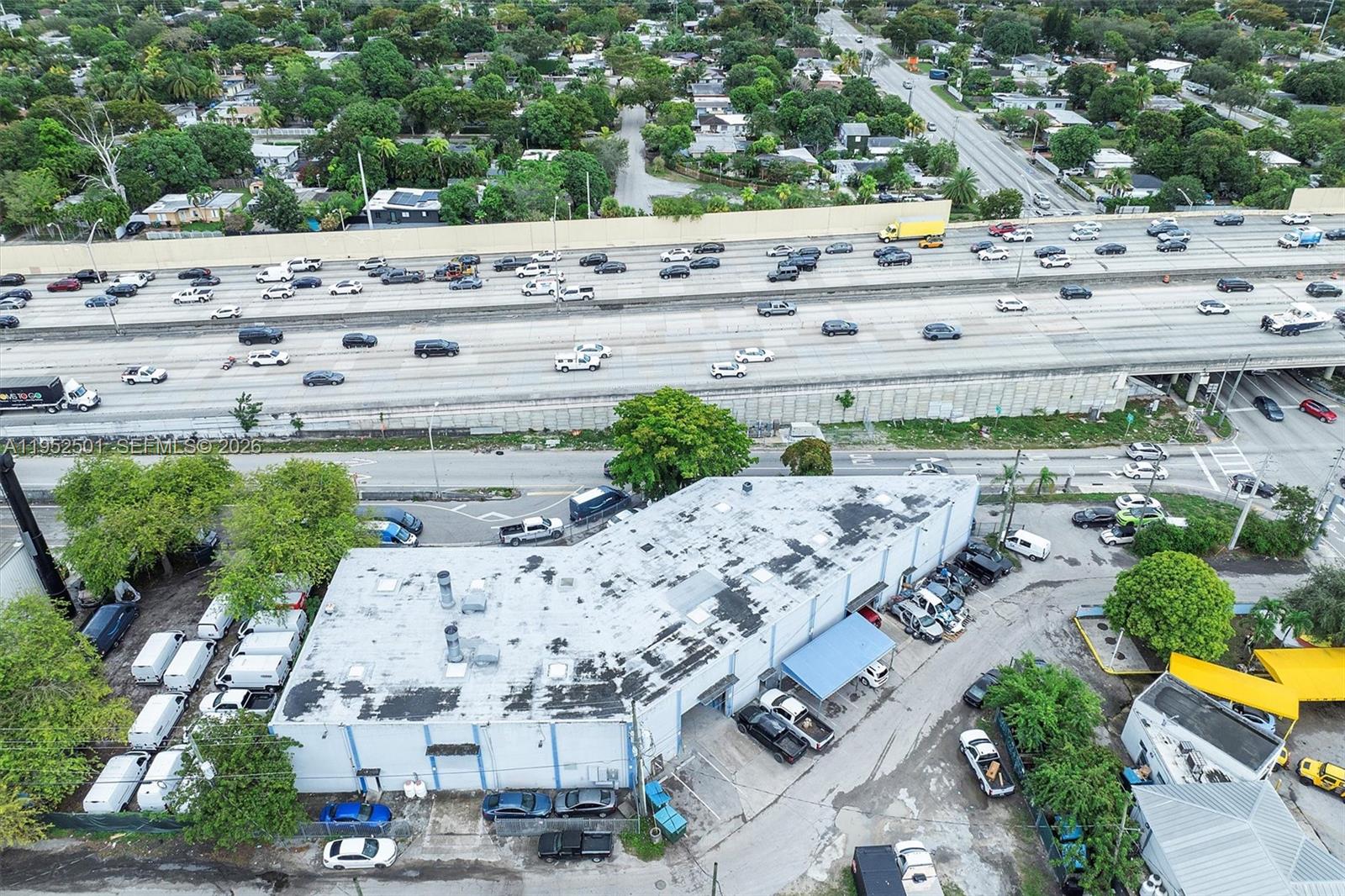 An aerial view shows a commercial warehouse building situated next to a multi-lane highway — 660 NW 137th St, North Miami FL 33168, NORTH MIAMI, FL
