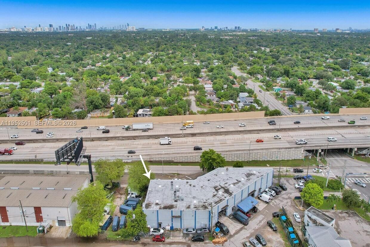 An aerial view shows a commercial building situated next to a multi-lane highway — 660 NW 137th St, North Miami FL 33168, NORTH MIAMI, FL