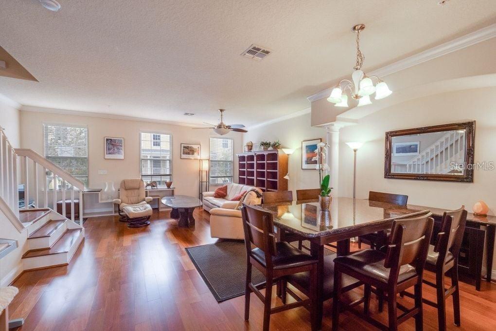 An open-concept living and dining area features hardwood floors, a staircase, and a chandelier — 1733 PROSPECT AVENUE, ORLANDO, FL
