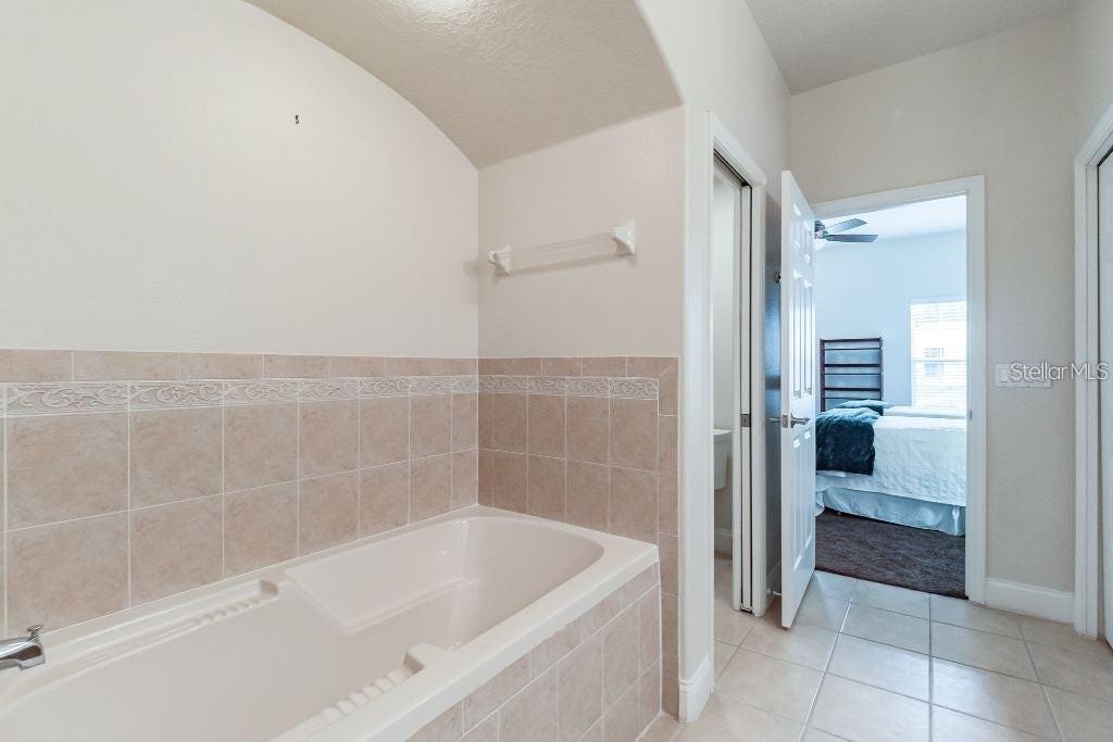 A bathroom features a tiled soaking tub and a doorway leading into a bedroom — 1733 PROSPECT AVENUE, ORLANDO, FL