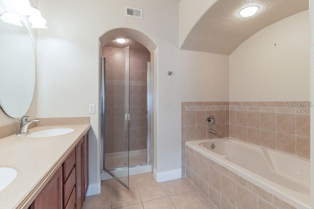 A bathroom features a double vanity, a glass-enclosed shower, and a tiled soaking tub — 1733 PROSPECT AVENUE, ORLANDO, FL