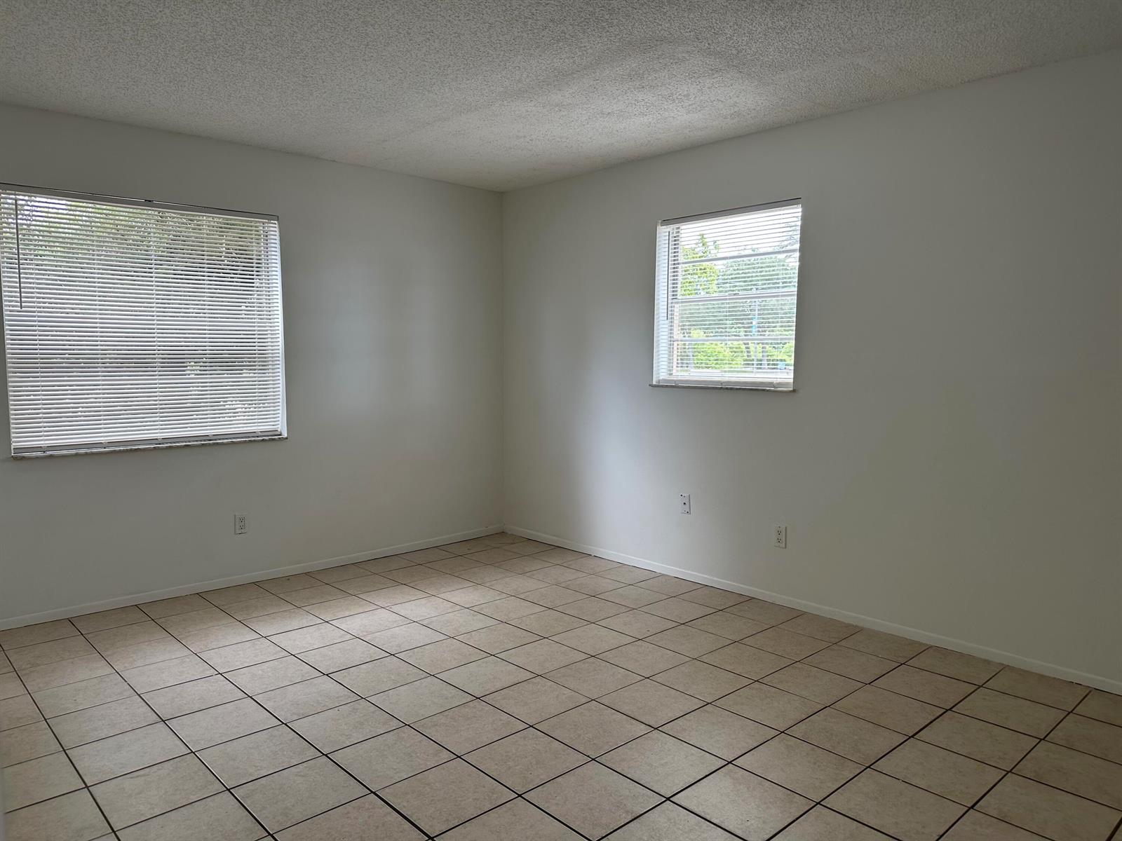An empty room with white walls, tile flooring, and two windows with closed blinds — 4606 SE Binnacle Way # 1, Stuart FL 34997, STUART, FL