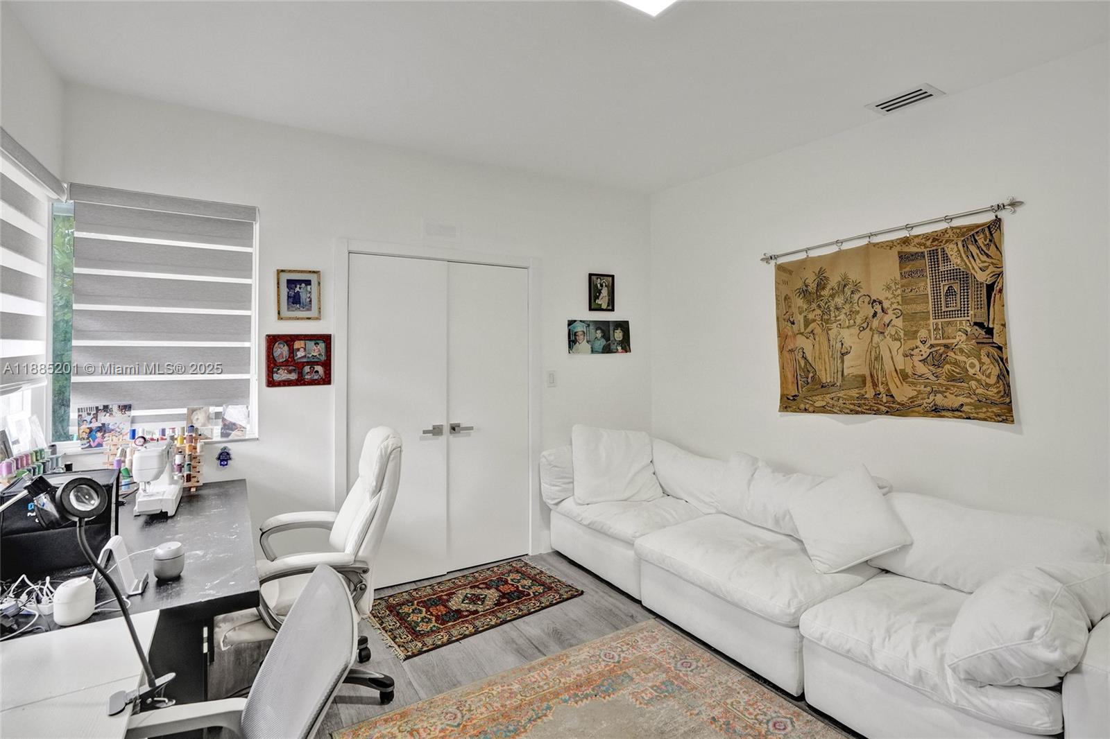 A room features a white sofa, a desk with chairs, and a wall-mounted tapestry — 3784 Sheridan Ave, Miami Beach FL 33140, MIAMI BEACH, FL