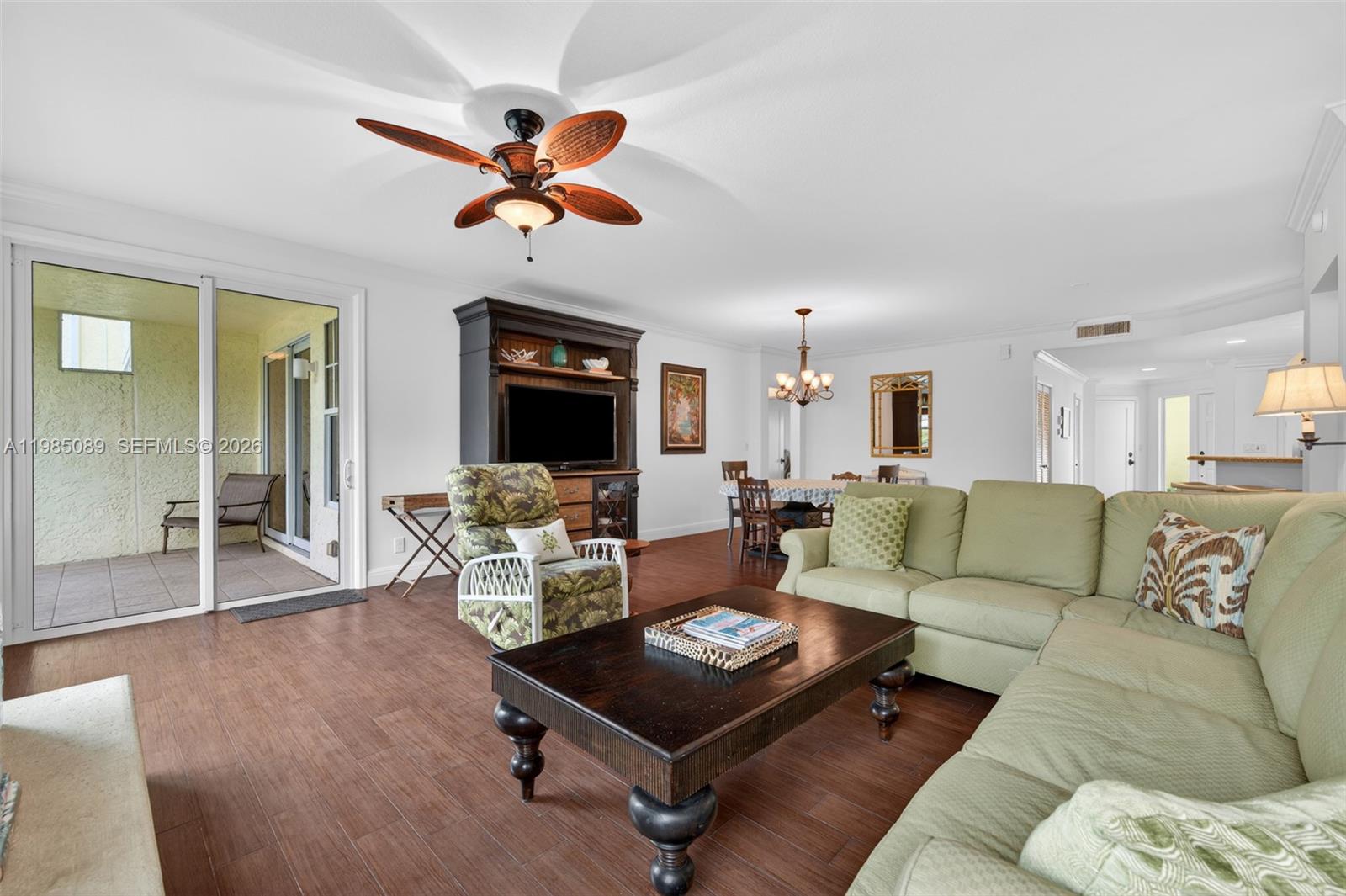 A living room with wood-look flooring, a green sectional sofa, and a ceiling fan — 1404 Mainsail Cir # 1404, Jupiter FL 33477, JUPITER, FL