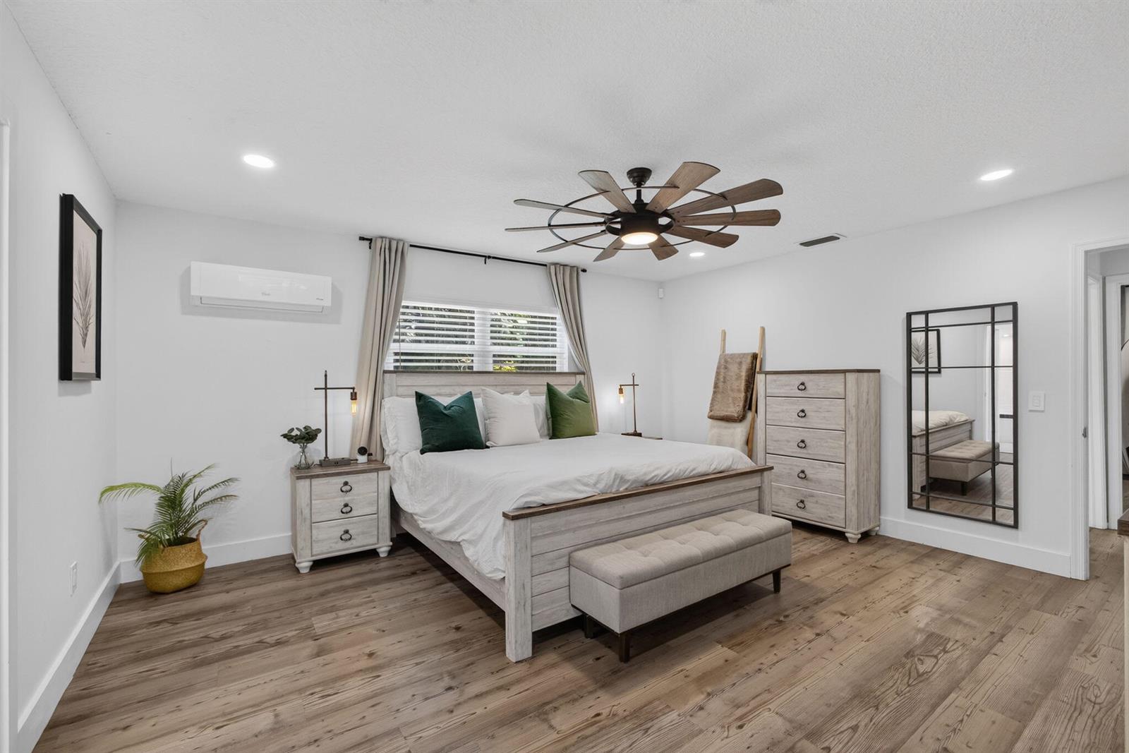 A bedroom features a bed, dresser, bench, and ceiling fan on wood-look flooring — 17968 Bridle Court, FL 33478, FL