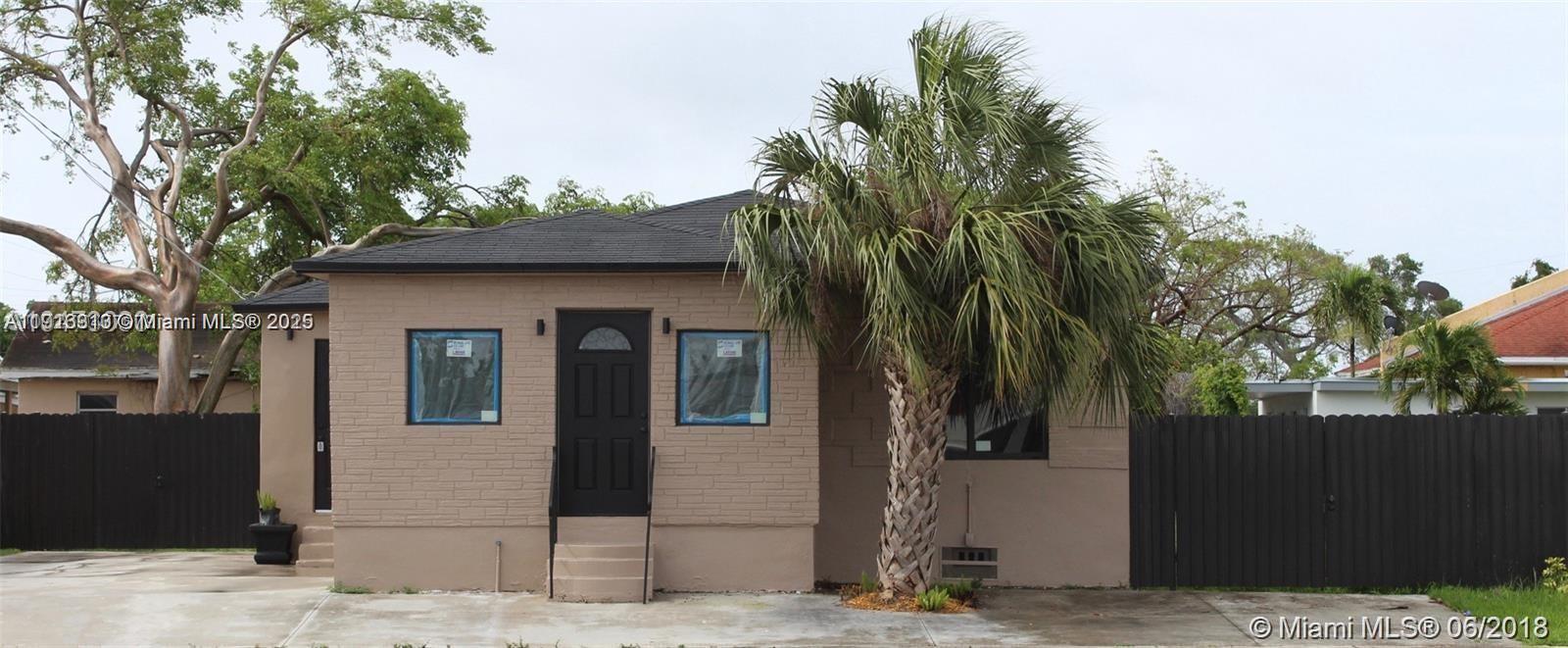 A single-story house with a tan facade, black front door, and a prominent palm tree — 107 W Pembroke Rd, Hallandale Beach FL 33009, HALLANDALE BEACH, FL