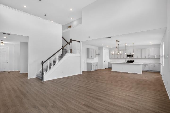 A long, narrow room with white walls, light wood-look flooring, and multiple windows — 17631 LAKE STAR ROAD, WINTER GARDEN, FL
