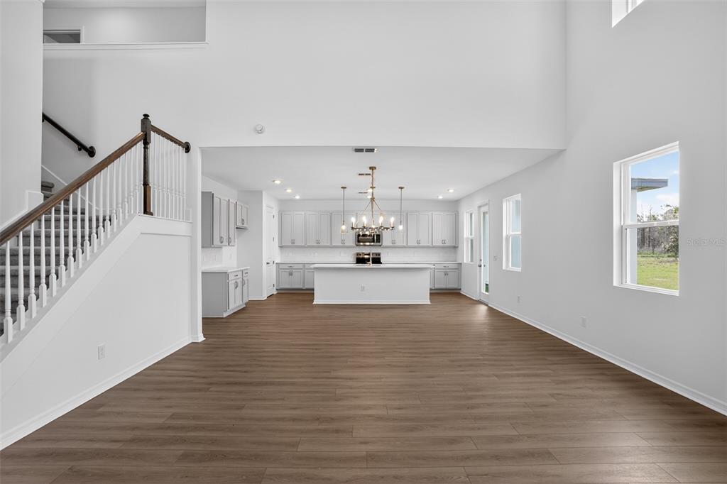 An empty room with white walls, wood-look flooring, and three windows — 17631 LAKE STAR ROAD, WINTER GARDEN, FL