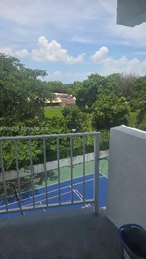 A view from a balcony overlooking a blue tennis court surrounded by trees — 492 NW 165 St Rd # C516, Miami FL 33169, MIAMI, FL