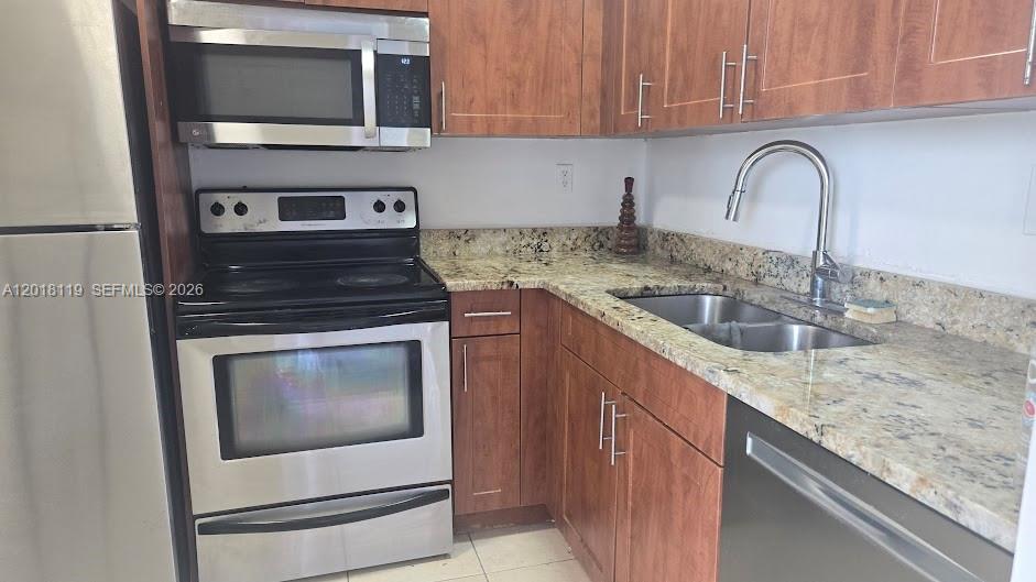 A kitchen features stainless steel appliances, wood cabinets, and granite countertops — 492 NW 165 St Rd # C516, Miami FL 33169, MIAMI, FL