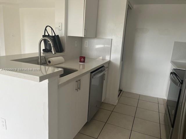 A kitchen features white cabinets, stainless steel appliances, and a peninsula with a sink — 15231 SW 80th St # 503, Miami FL 33193, MIAMI, FL