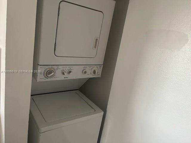 A stacked white washer and dryer unit is installed in a small laundry closet — 15231 SW 80th St # 503, Miami FL 33193, MIAMI, FL